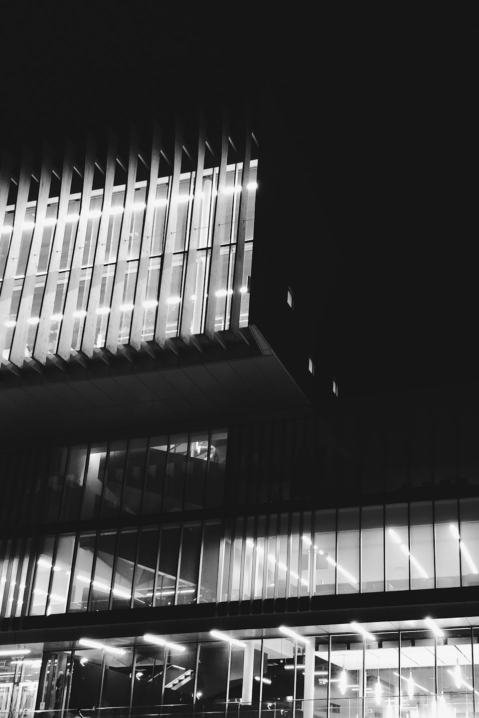 Modern office building with illuminated windows at night.