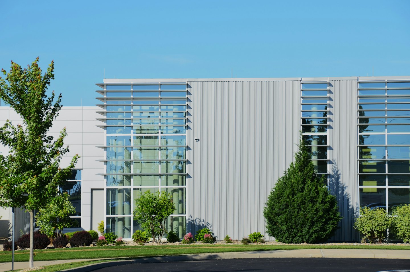 Modern commercial building with glass windows and grey siding.